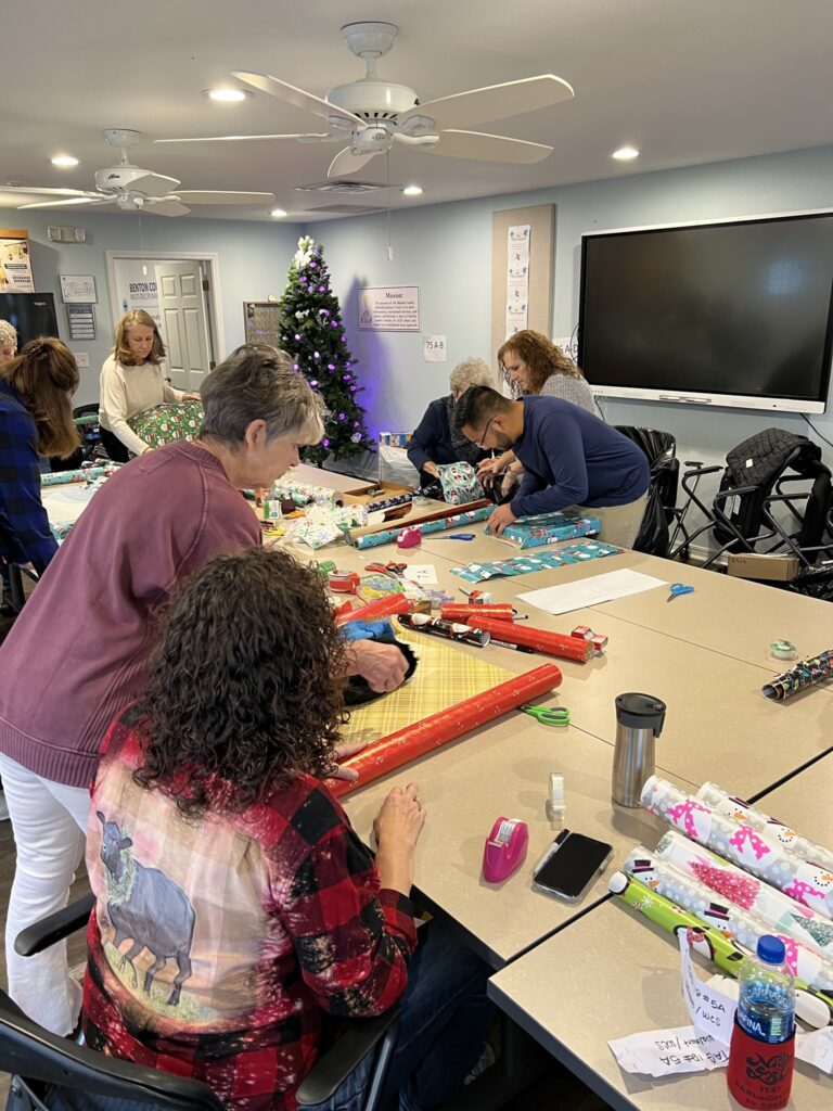 Volunteers wrapping Christmas gifts for families in need