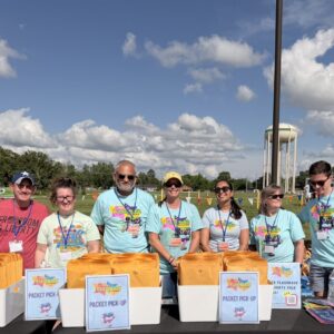 CFAC volunteers at the packet pickup table during the Flashback 5K and Family Fun Festival.